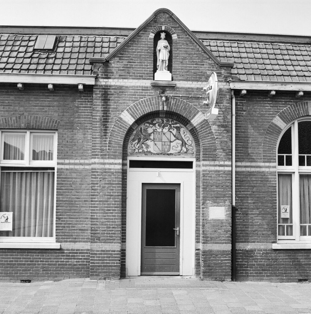 Ingang van het Patronaat met heiligenbeeld